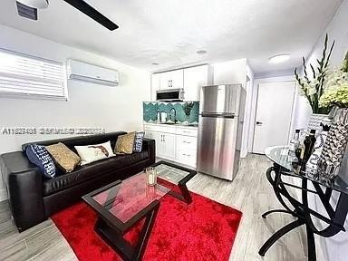 2425 Southwest 26th Terrace, Unit A Miami, FL 33133 - Photo 2 of 6 a living room with furniture and a refrigerator