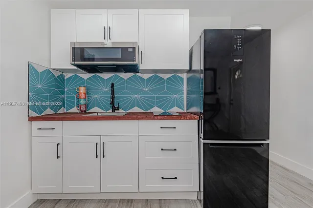 a kitchen with stainless steel appliances granite countertop a refrigerator and a microwave