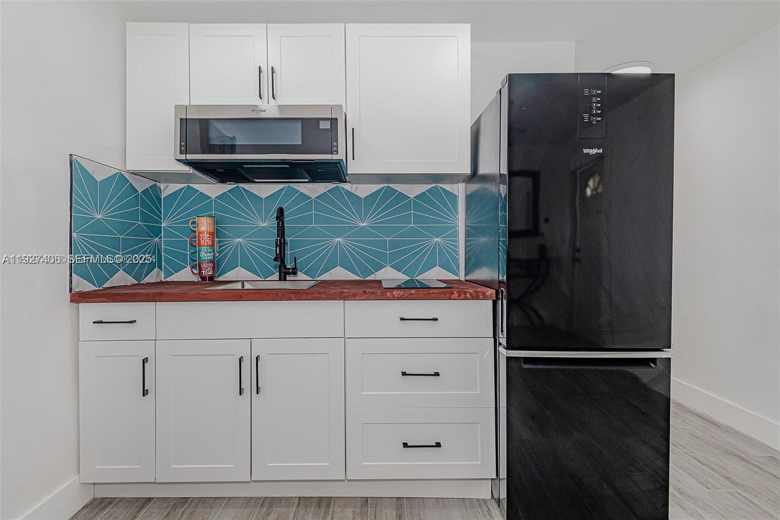 2425 Southwest 26th Terrace, Unit A Miami, FL 33133 - Photo 4 of 6 a kitchen with stainless steel appliances granite countertop a refrigerator and a microwave