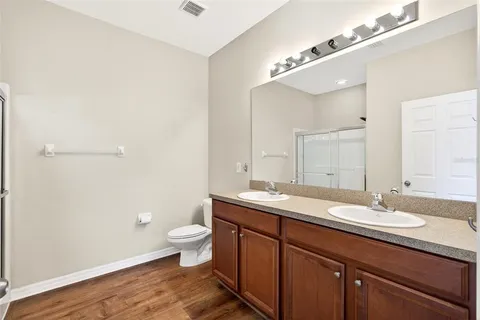 a bathroom with a granite countertop sink a toilet and a mirror