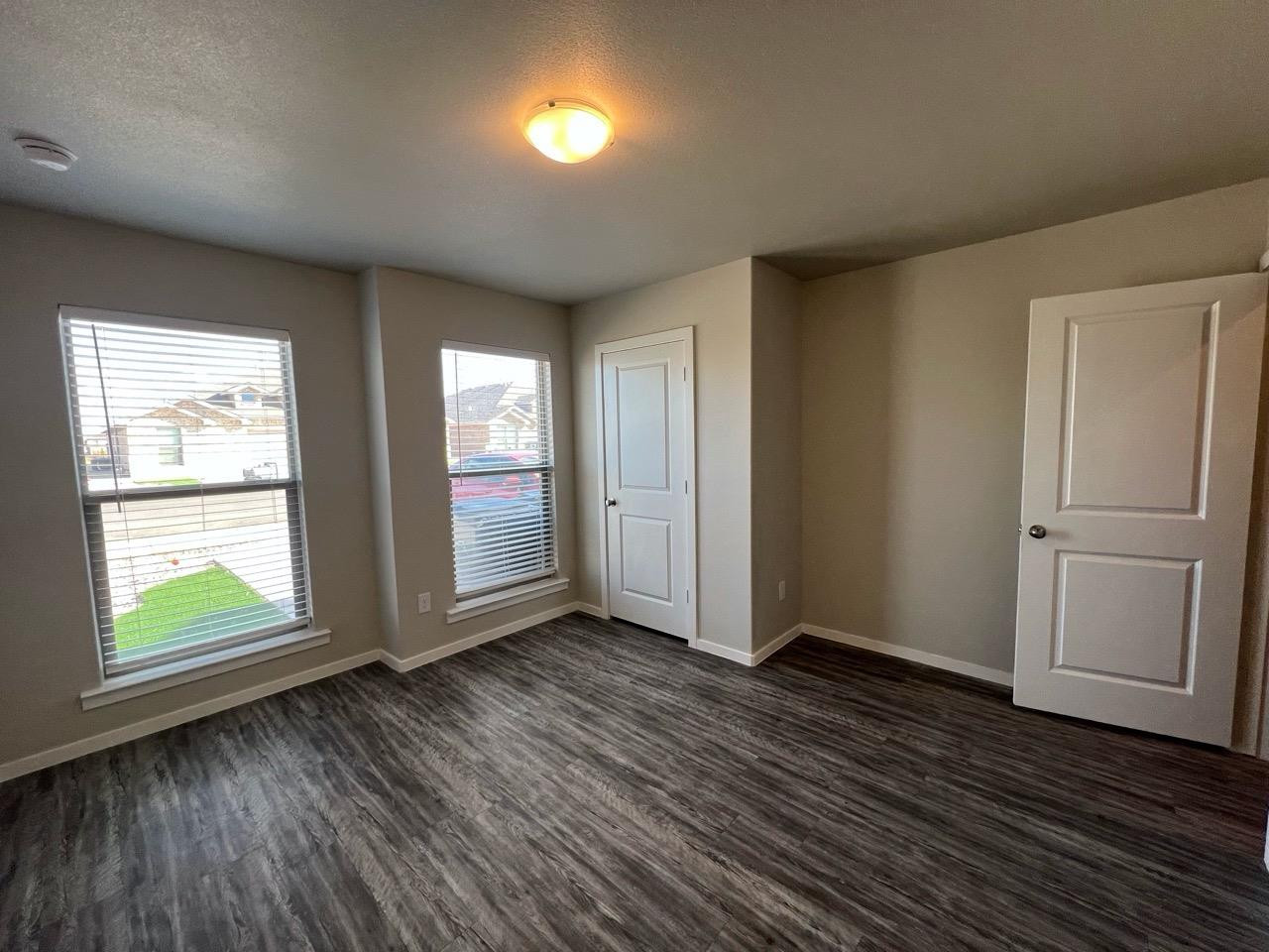 2121 North Avenue J, Unit A Lubbock, TX 79403 - Photo 2 of 20 an empty room with wooden floor and windows