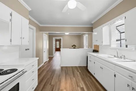 a kitchen with stainless steel appliances a white cabinets and wooden floor