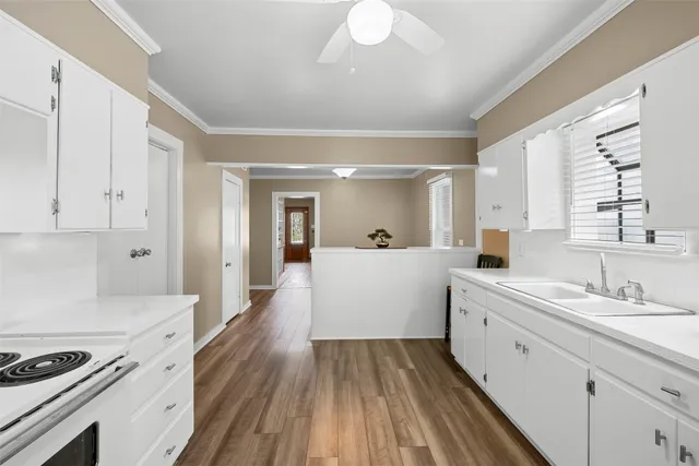 a kitchen with stainless steel appliances a white cabinets and wooden floor