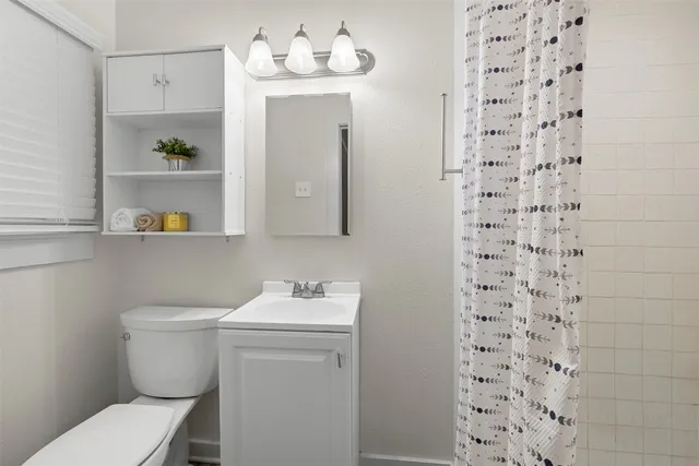 a spacious bedroom with a large bed chandelier and a window