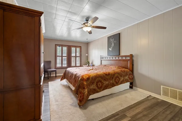a spacious bedroom with a large bed chandelier and a window