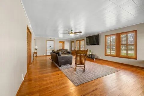 a living room with furniture a dining table and wooden floor