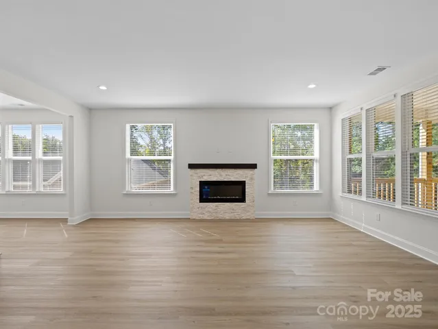 an empty room with wooden floor and a fireplace