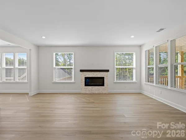 an empty room with wooden floor and a fireplace