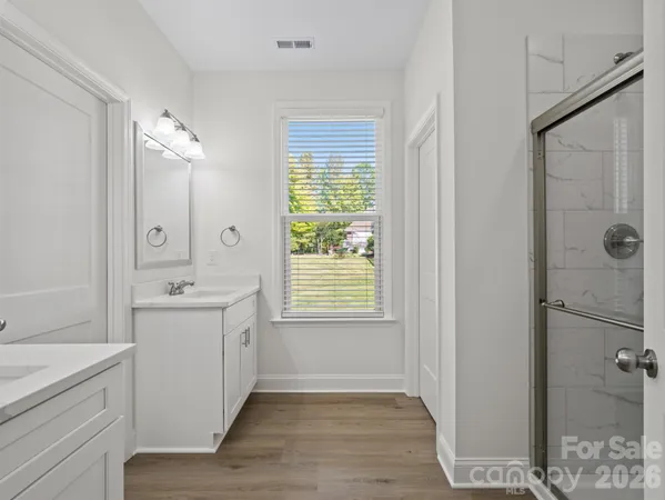 a bathroom with a granite countertop sink a toilet and shower