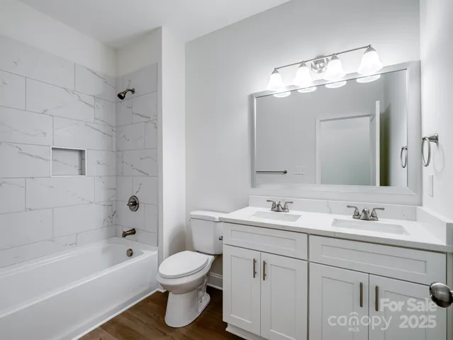 a bathroom with a sink a toilet a mirror a bathtub and shower