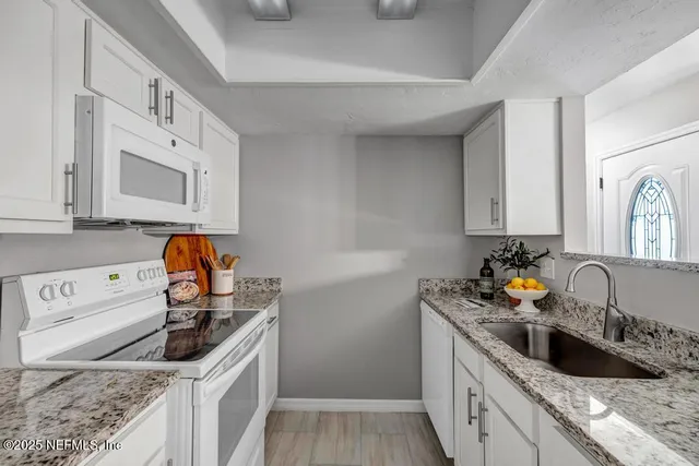 a kitchen with stainless steel appliances granite countertop a sink stove and cabinets