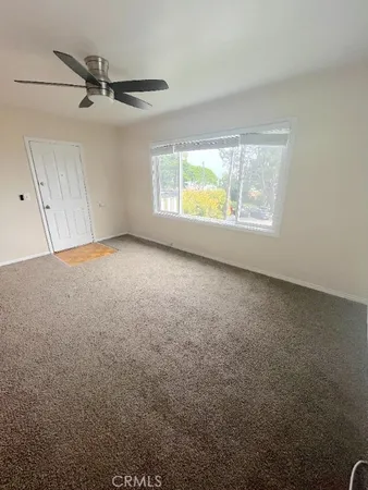 a view of a livingroom with a ceiling fan and window