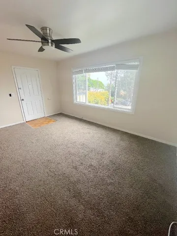 a view of a livingroom with a ceiling fan and window