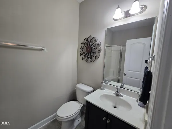 a bathroom with a toilet sink vanity and mirror