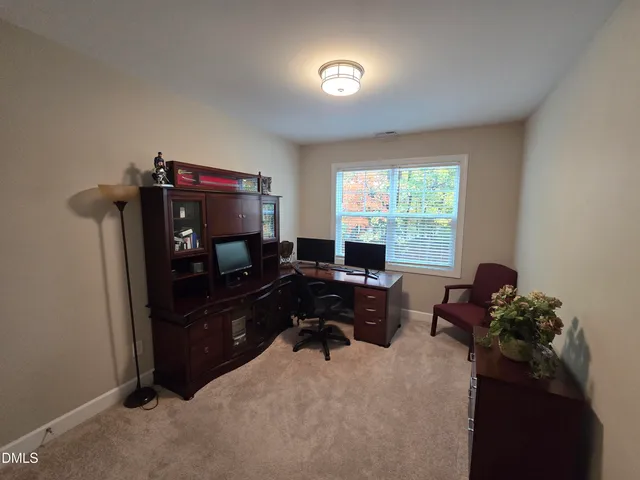 a view of a workspace with furniture and a window