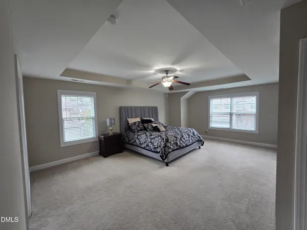 a spacious bedroom with a bed and a chandelier