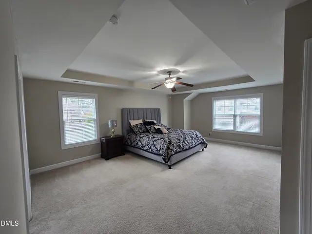 a spacious bedroom with a bed and a chandelier