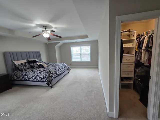 a spacious bedroom with a bed and a chandelier