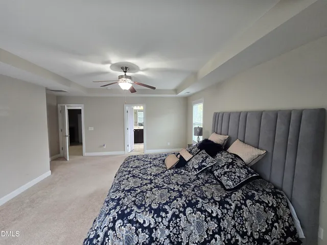 a spacious bedroom with a bed and a chandelier