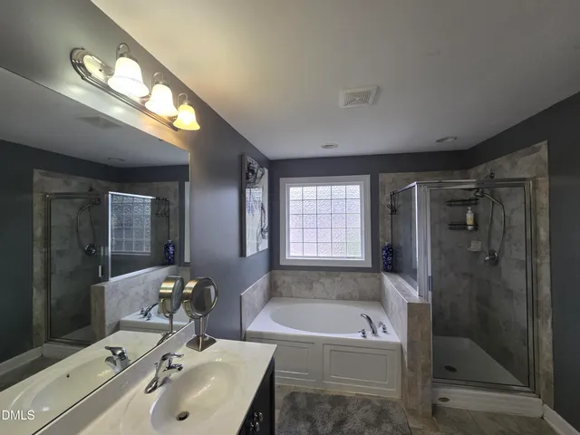 a bathroom with a tub sink and mirror