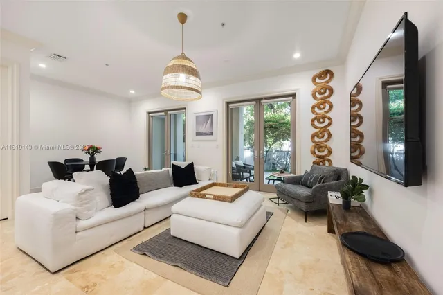 a living room with furniture potted plant and a large window