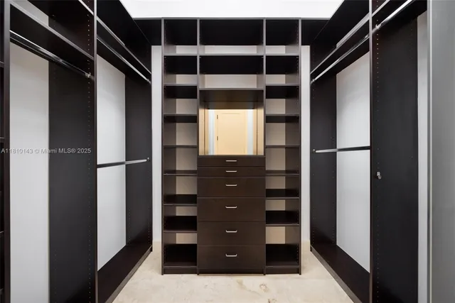 a view of walk in closet with empty racks