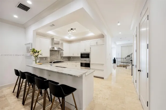 a kitchen with refrigerator and chairs