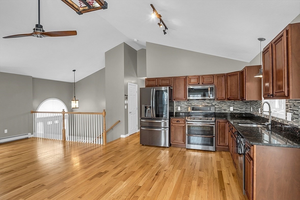 535 Clark Street Gardner, MA 01440 - Photo 10 of 41 a kitchen with stainless steel appliances granite countertop a refrigerator a stove top oven a sink dishwasher and wooden cabinets with wooden floor