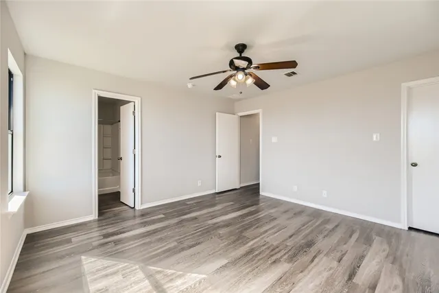 a view of room with wooden floor and ceiling fan