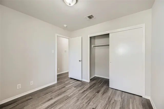 an empty room with wooden floor and closet