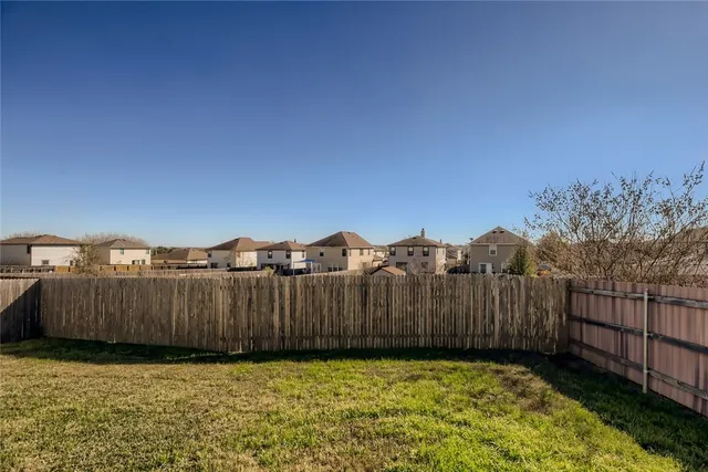 a view of a backyard with wooden fence