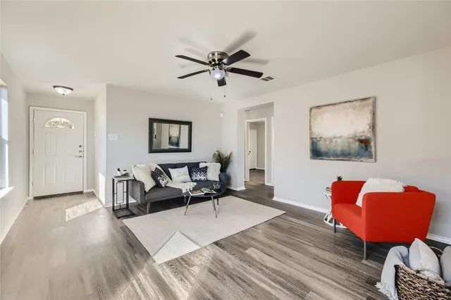 a living room with furniture and a wooden floor