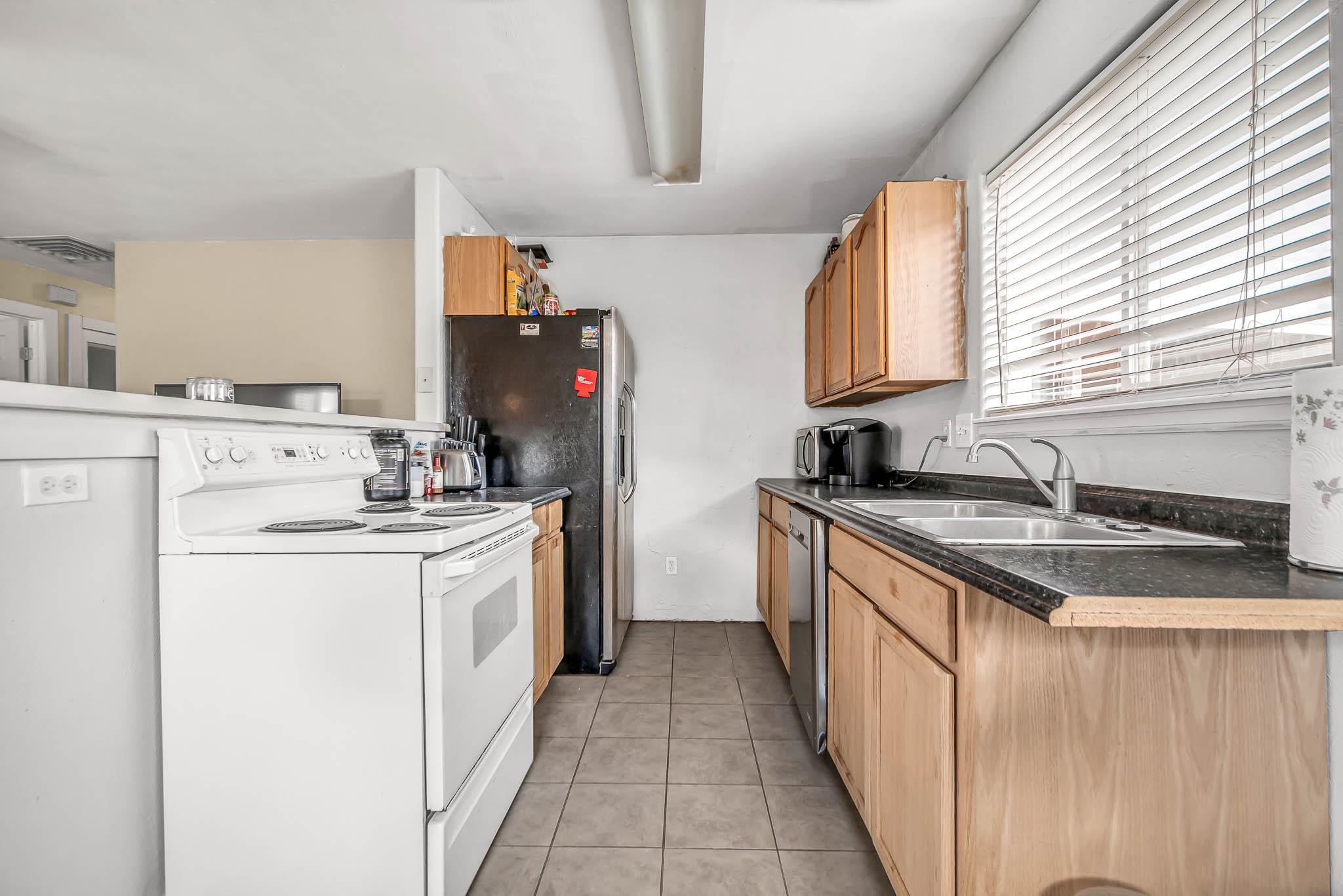 389 Sunnyside Circle, Unit A Grand Junction, CO 81504 - Photo 11 of 21 a kitchen with granite countertop a sink stove and refrigerator