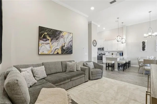a living room with furniture a dining table and a chandelier