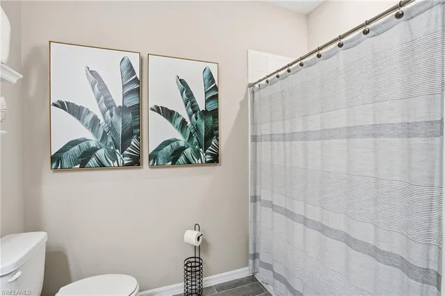 a bathroom with a toilet and a shower curtain