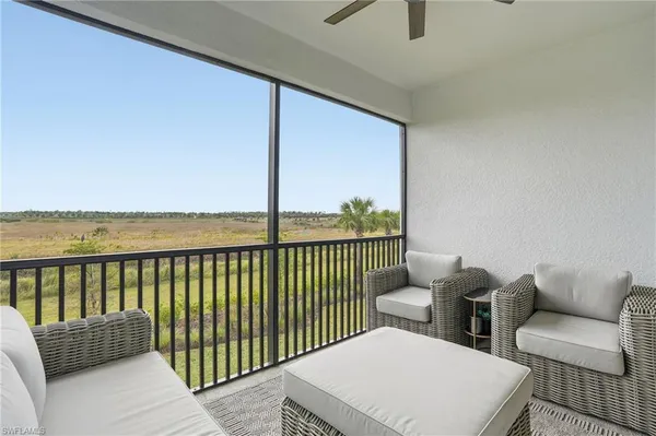 a balcony with couple of white chairs
