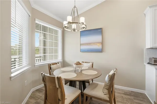 a dining room with furniture a chandelier and wooden floor