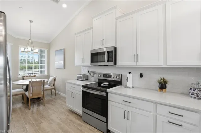 a kitchen with stainless steel appliances white cabinets and wooden floor