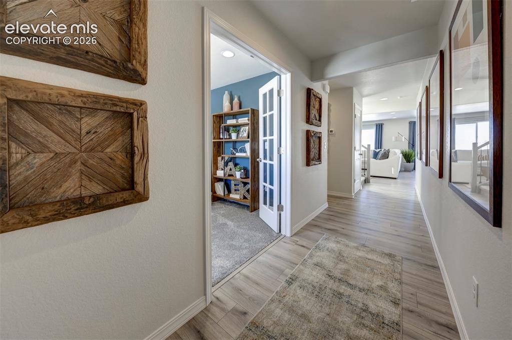 8230 Lemon Grass Road Falcon, CO 80831 - Photo 4 of 22 a view of a hallway with wooden floor and windows