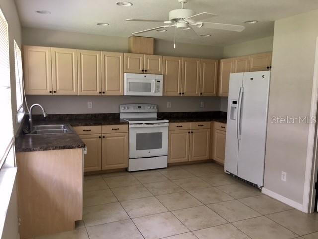 641 Constance Road Venice, FL 34293 - Photo 5 of 14 a kitchen with a stove sink and refrigerator