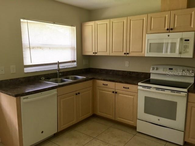 641 Constance Road Venice, FL 34293 - Photo 8 of 16 a kitchen with granite countertop white cabinets and sink