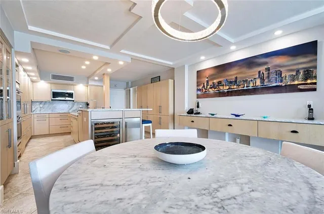 a large kitchen with stainless steel appliances a stove a sink a oven a dining table and chairs