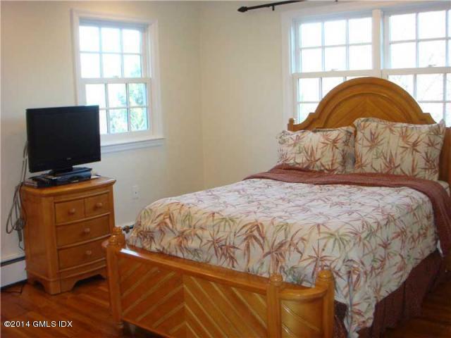 16 MacKenzie Glen Greenwich, CT 06830 - Photo 16 of 26 a bedroom with a bed and flat screen tv