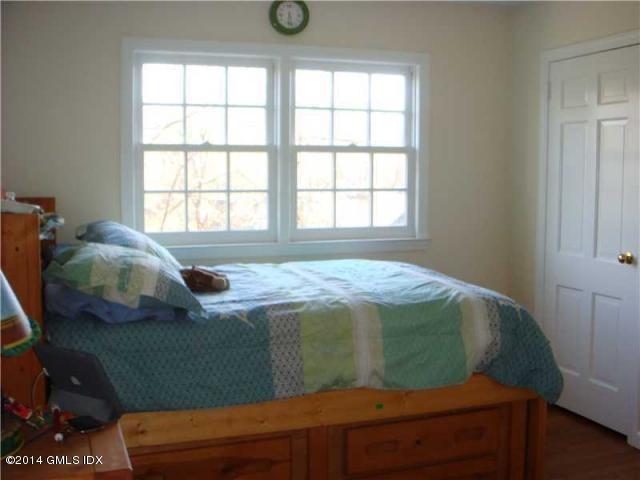 16 MacKenzie Glen Greenwich, CT 06830 - Photo 17 of 26 a bed sitting in a bedroom next to a window
