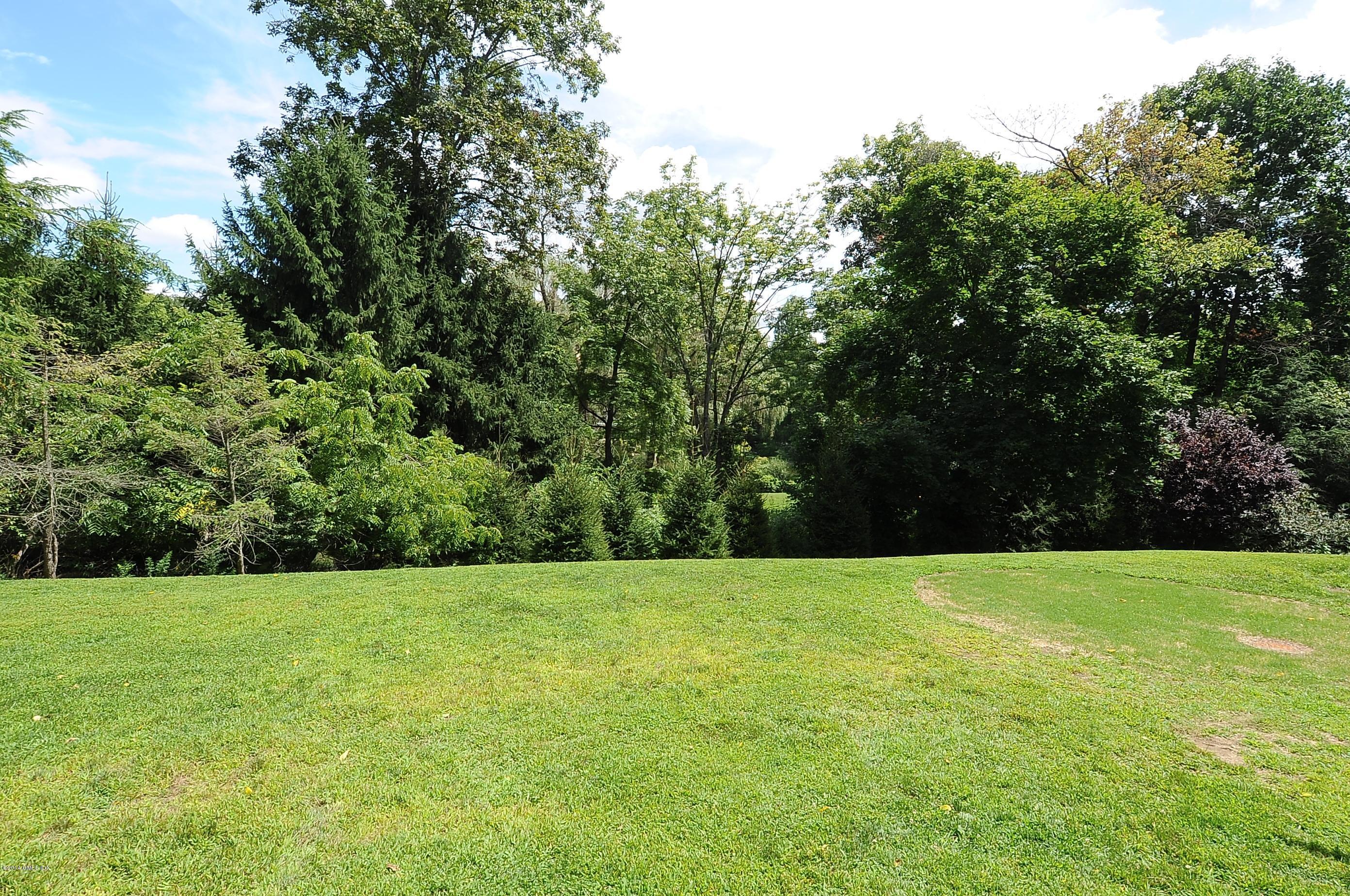 16 MacKenzie Glen Greenwich, CT 06830 - Photo 24 of 26 a view of green field with trees in the background