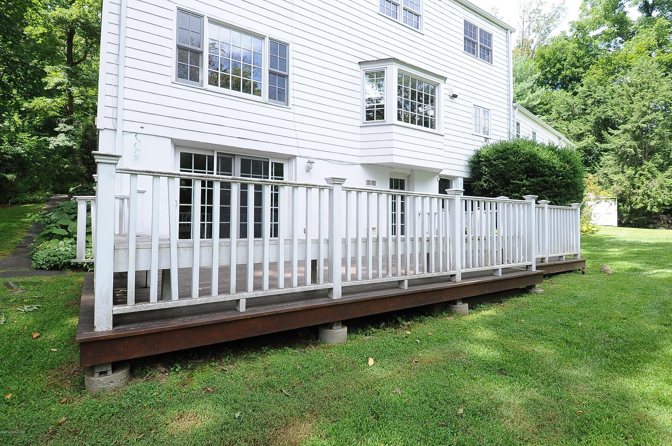 16 MacKenzie Glen Greenwich, CT 06830 - Photo 6 of 26 a view of a house with a backyard and wooden deck