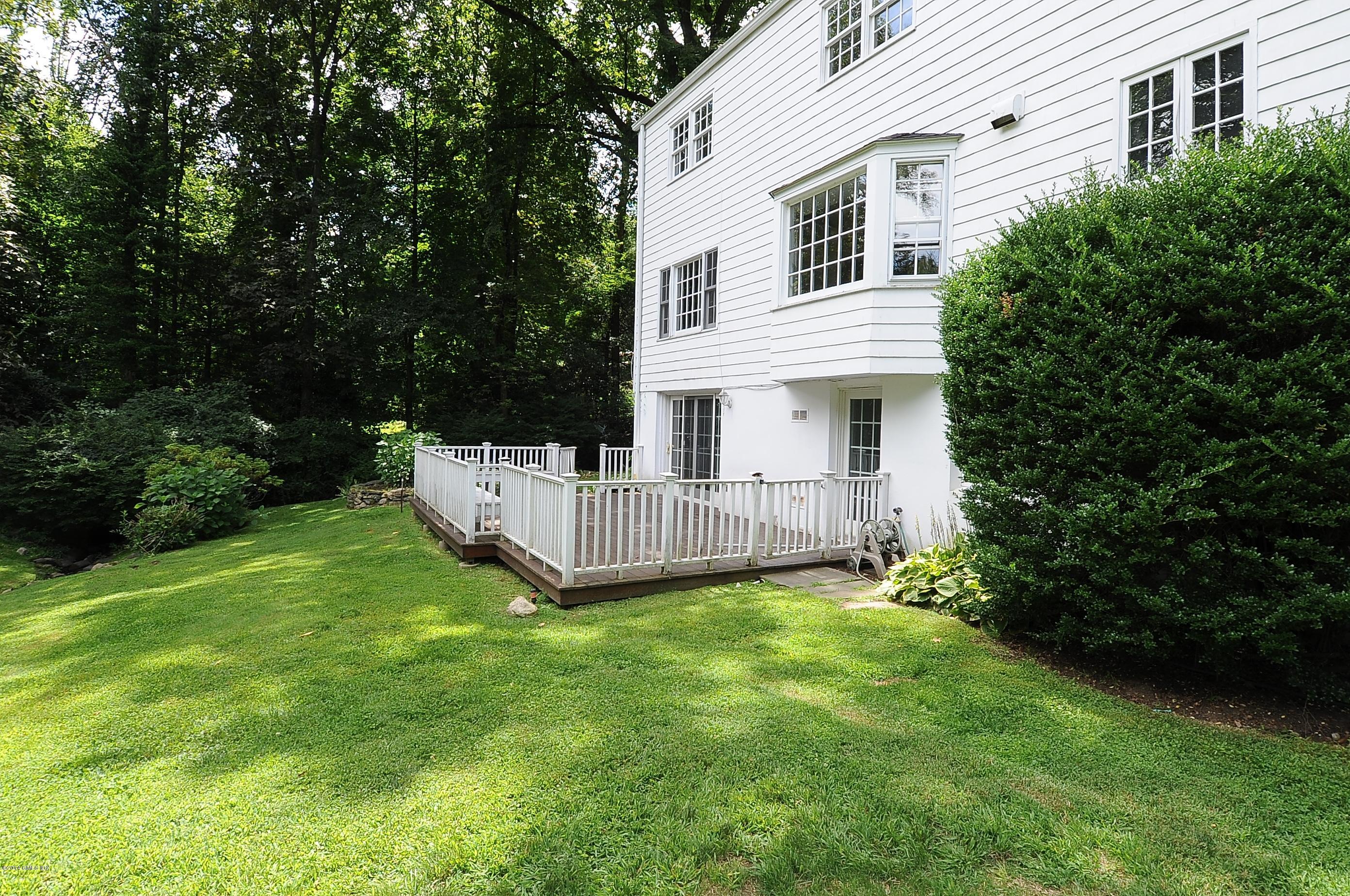 16 MacKenzie Glen Greenwich, CT 06830 - Photo 7 of 26 a view of a house with a yard and deck