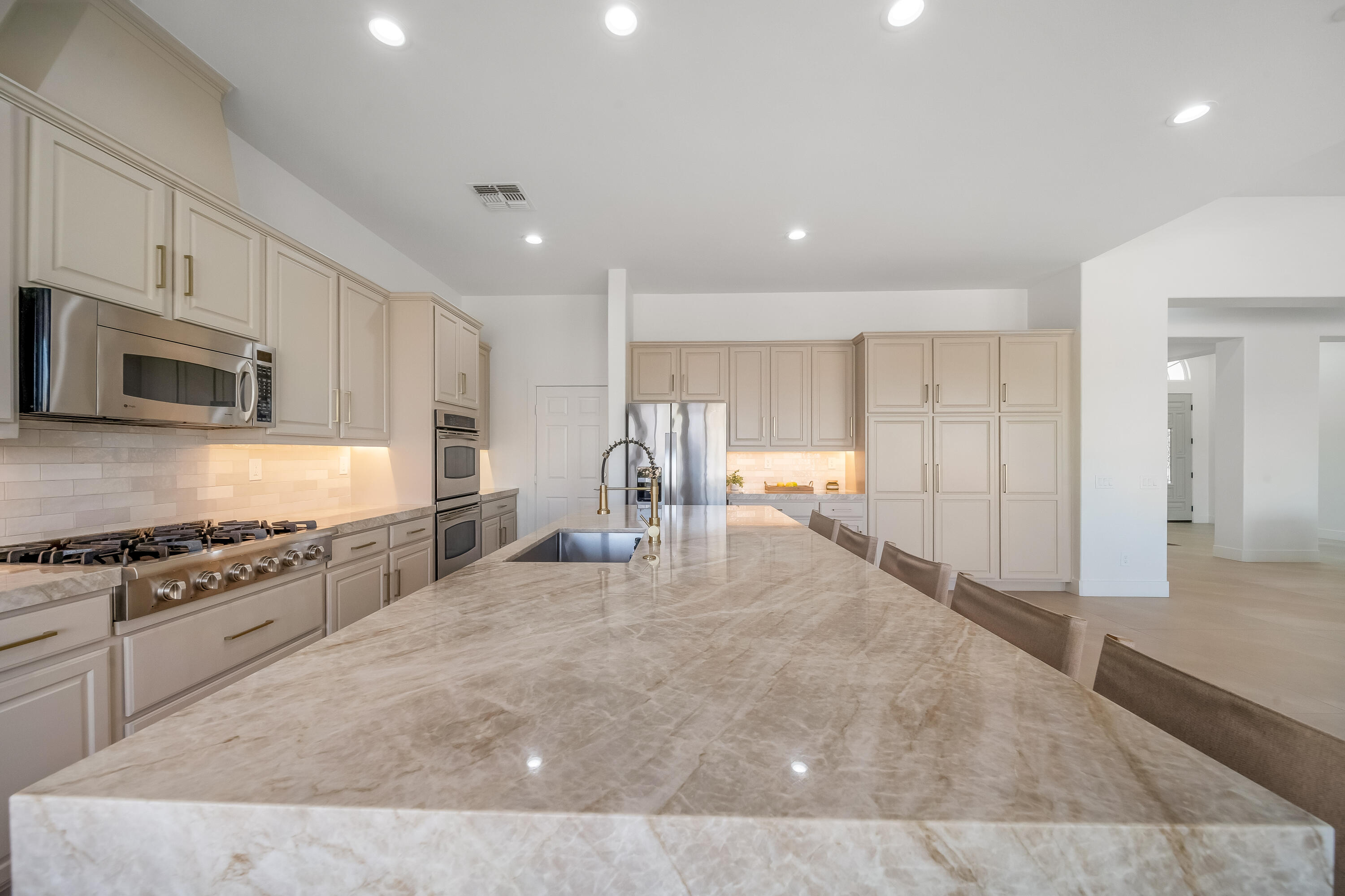 80262 Amazon Avenue Indio, CA 92201 - Photo 18 of 69 a large white kitchen with stainless steel appliances granite countertop a stove a sink a refrigerator and white cabinets