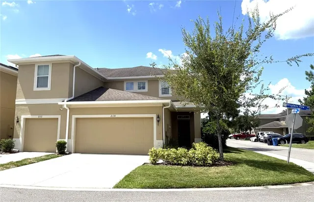 a front view of a house with a garden and trees