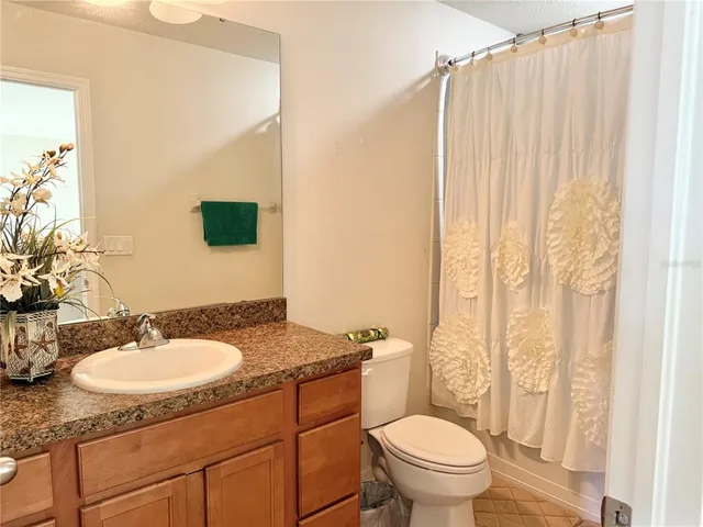 a bedroom with a bed and a flat tv screen on the dresser